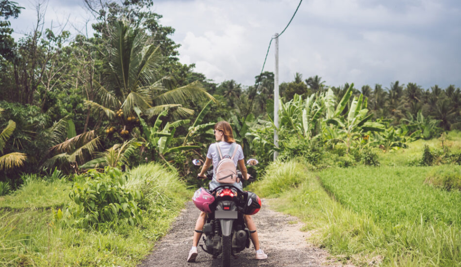 Een vrouw verkent Bali op een scooter zonder helm.