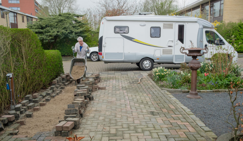 Iemand is de camper of caravan voor de deur parkeren.