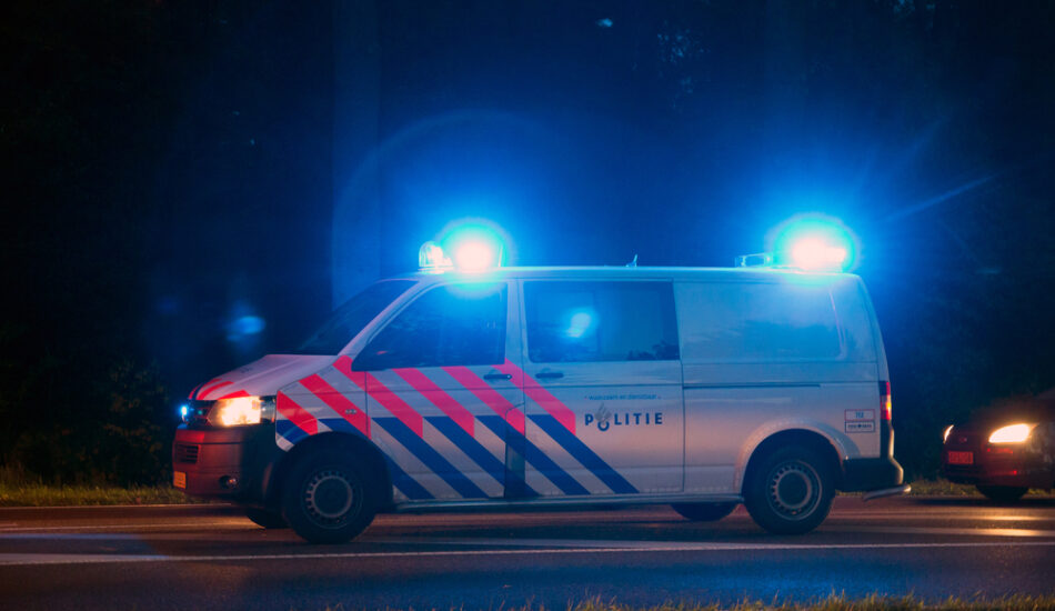 Een politieauto met blauwe zwaailichten.