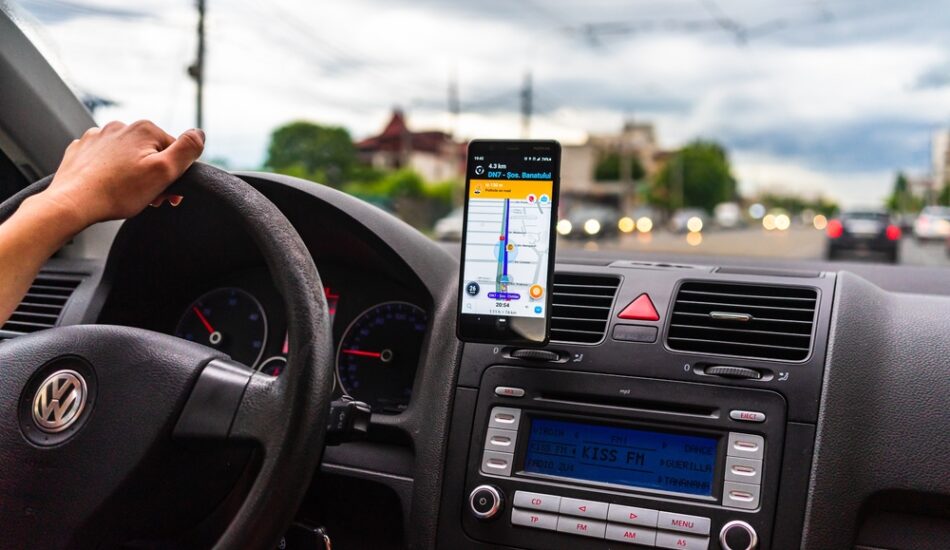 Een persoon die zijn navigatie met flitsmeldingen in de auto gebruikt.