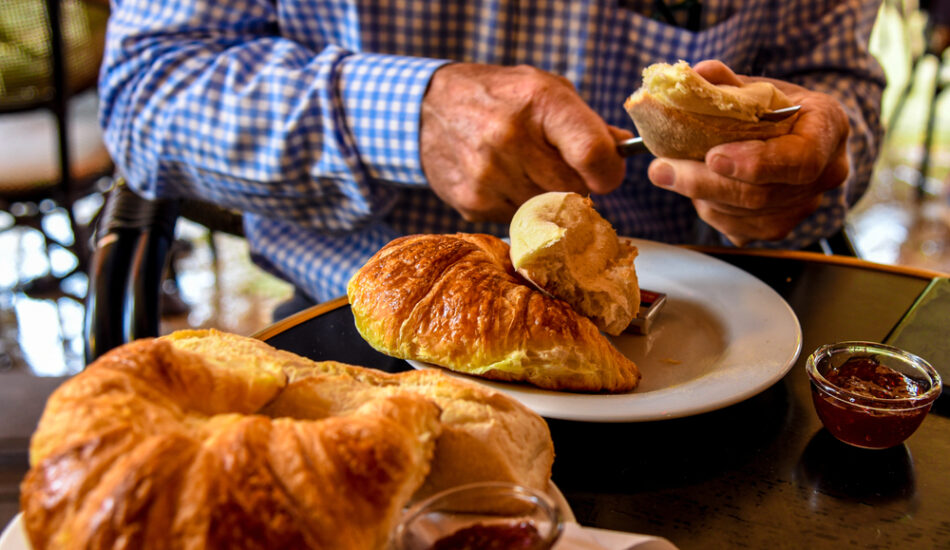 Een man belegt zijn croissant op vakantie.